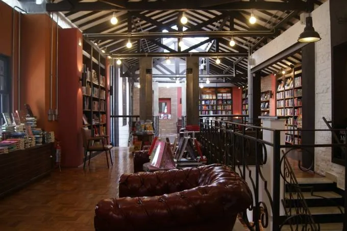 interior de livraria calma com prateleiras de livros ao fundo e poltrona confortável à frente