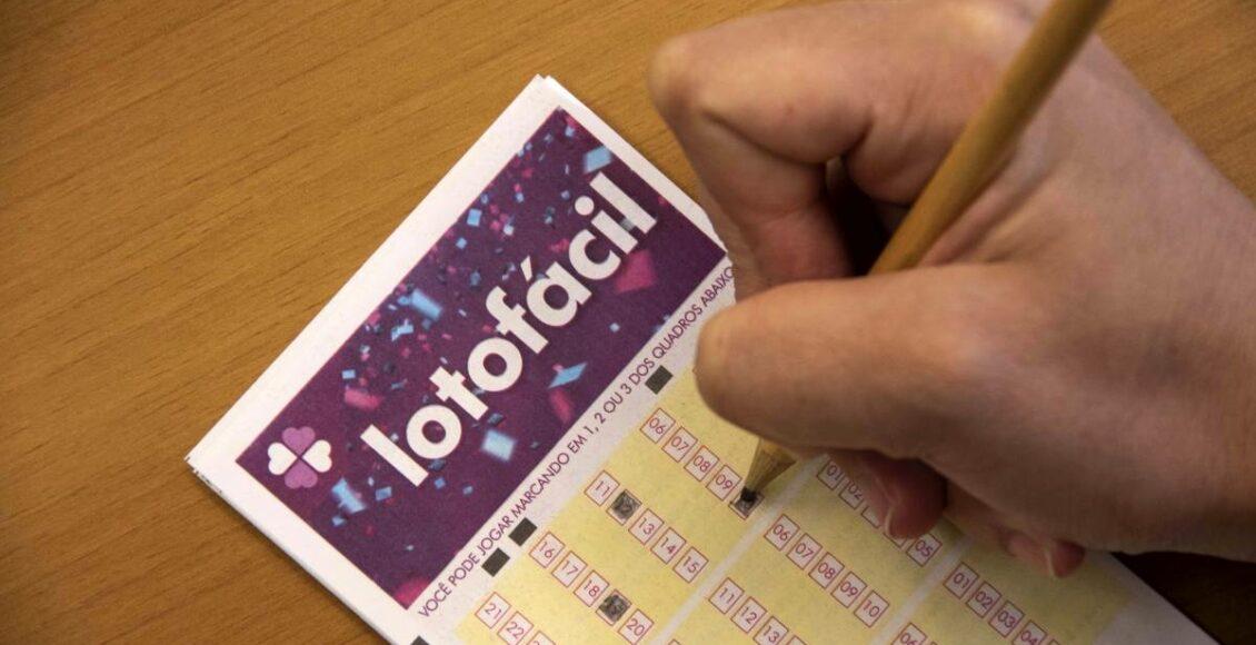 lotofácil concurso 2084 - A imagem mostra uma mão segurando um lápis e marcando números no volante da Lotofácil