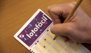 lotofácil concurso 2084 - A imagem mostra uma mão segurando um lápis e marcando números no volante da Lotofácil
