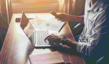 Vendas por whatsapp: homem digitando no notebook e mexendo no celular