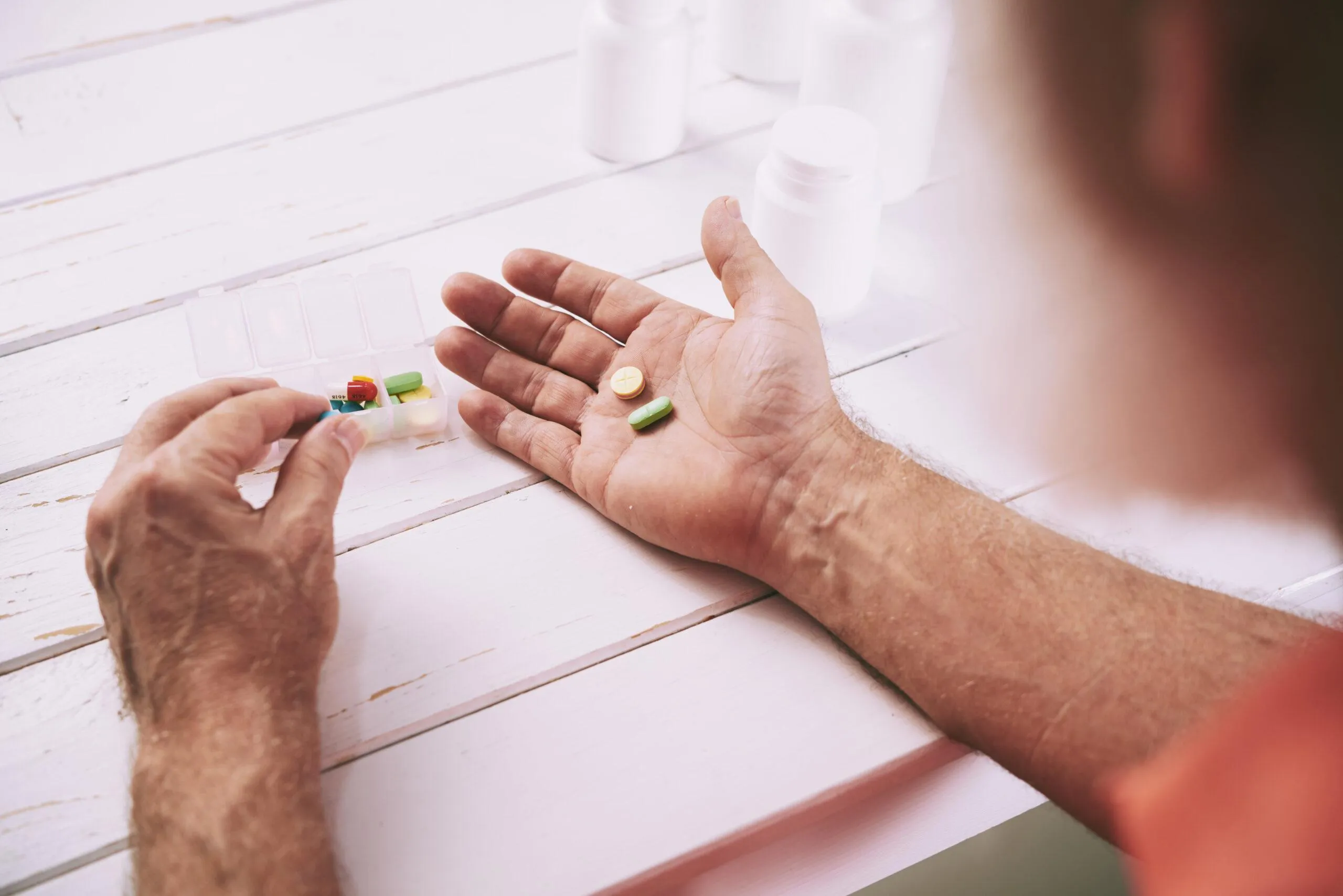 Homem idoso segurando medicamentos INSS