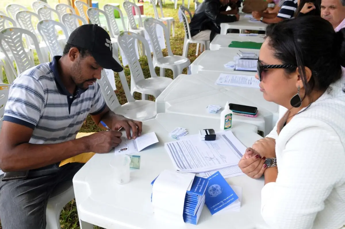 Pessoa tirando sua Carteira de Trabalho. Desempregados.