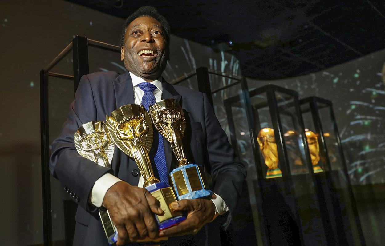 Pelé segura três Copas do Mundo, um de seus recordes