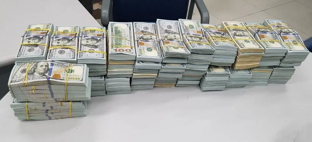 pilha de notas de 100 dólares sobre uma mesa