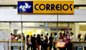 Foto mostra faixada dos Correios com pessoas na entrada
