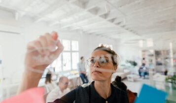 mulher escrevendo em lousa de vidro inteligente