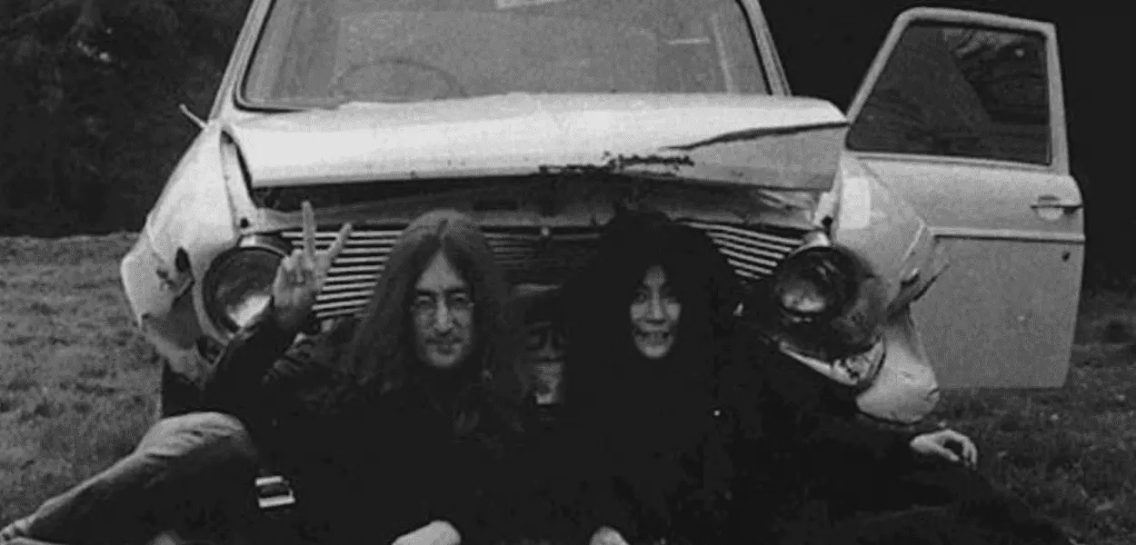 John Lennon e Yoko Ono em frente ao carro batido