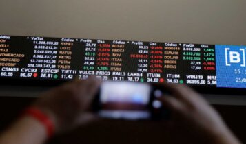 Devo comprar o índice Bovespa? saiba como encontrar ação barata painel com cotações, investidor buscando ações baratas
