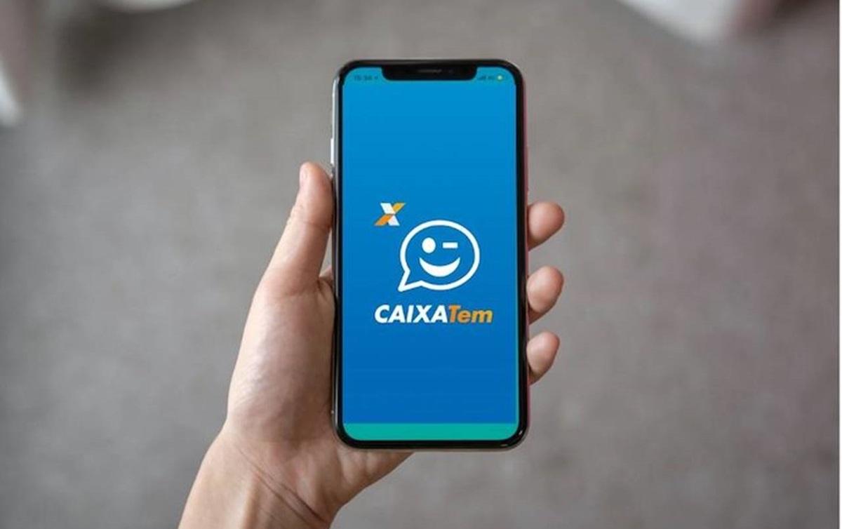 Homem segurando celular no app Caixa Tem. Poupança digital Caixa Tem