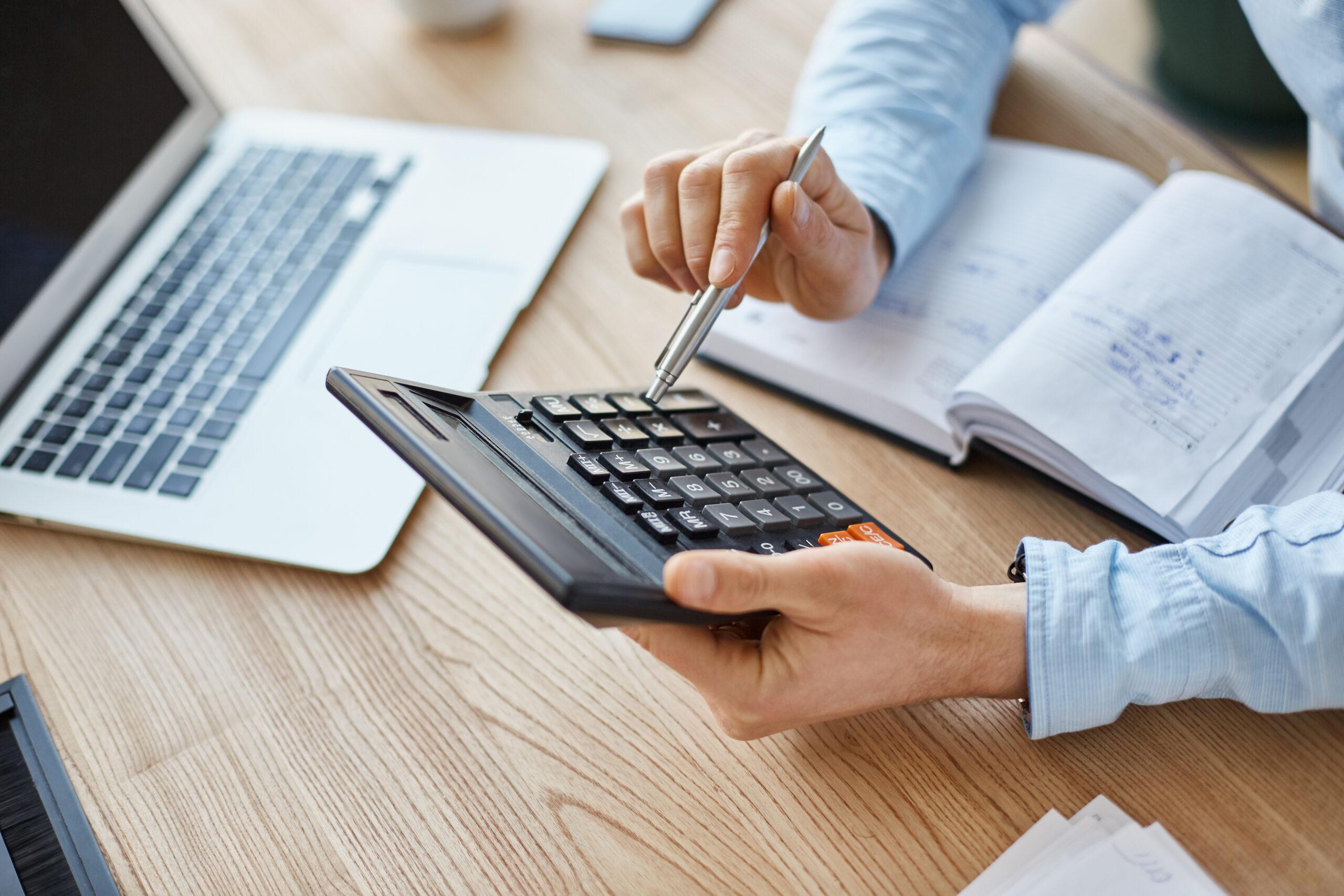 Quanto custa ser MEI. Pessoas usando calculadora