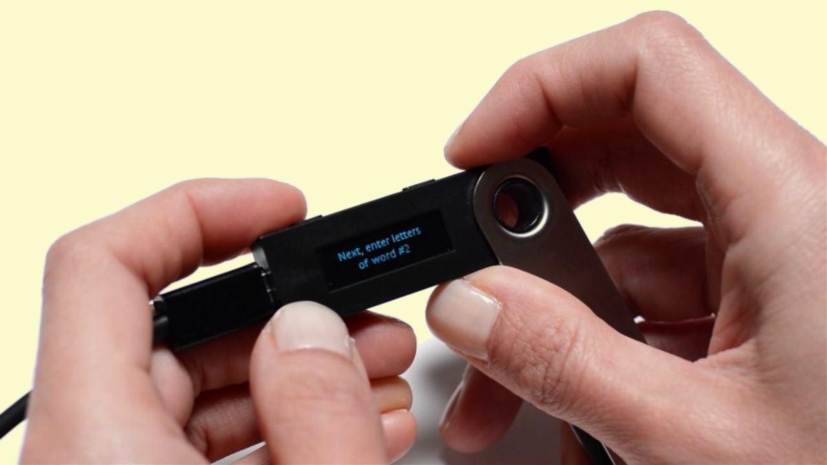 segurando hardware wallet Ledger Nano