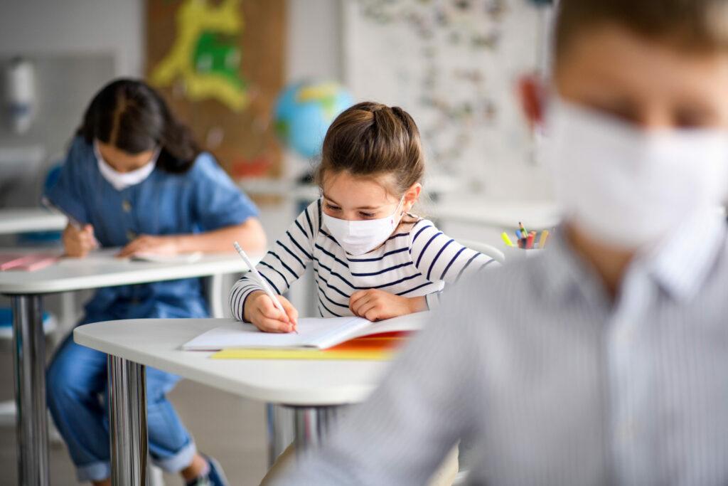 Sala de aula com crianças usando máscaras