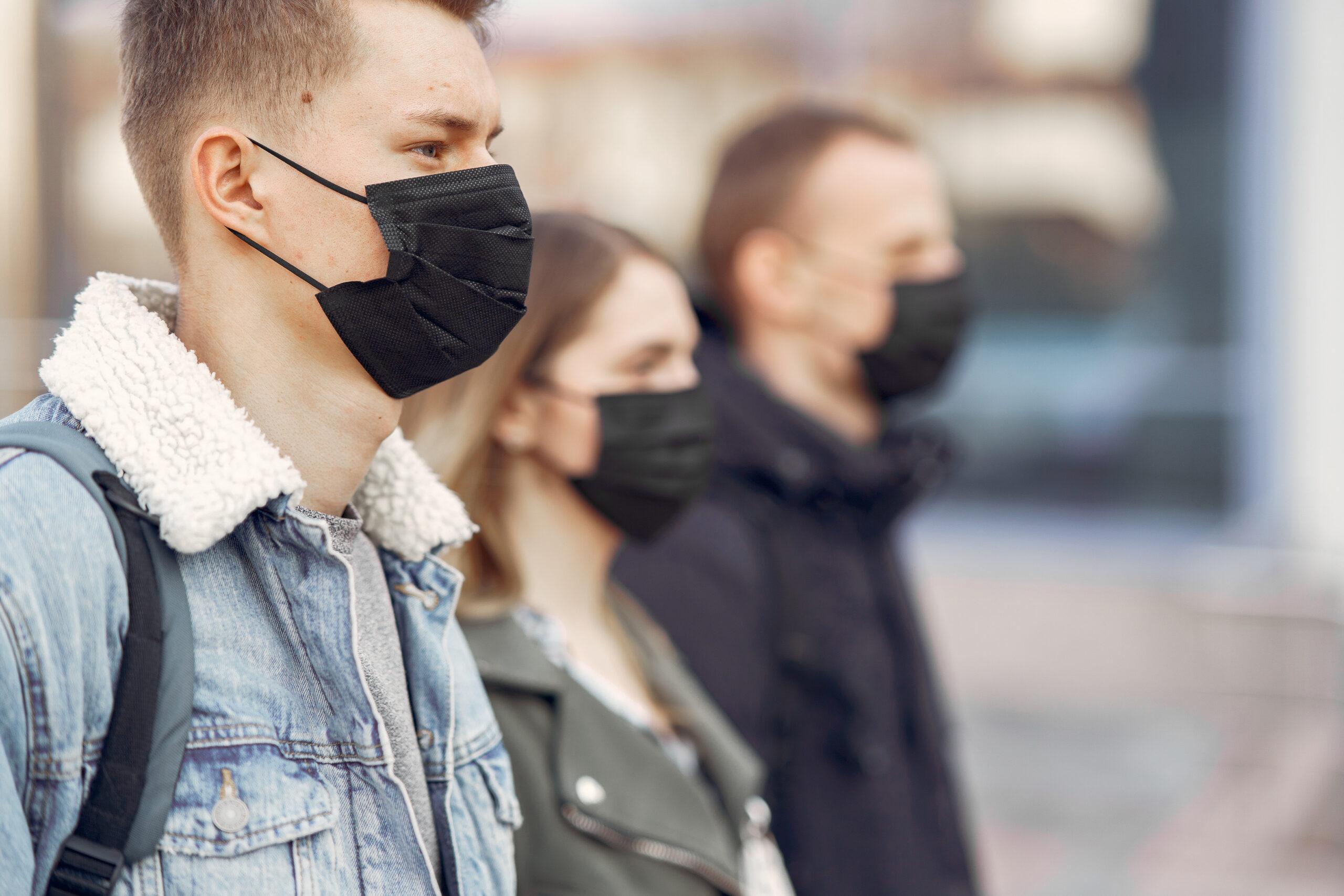 People in masks stands on the street scaled
