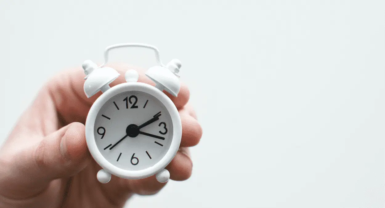Imagem de uma mão segurando um relógio