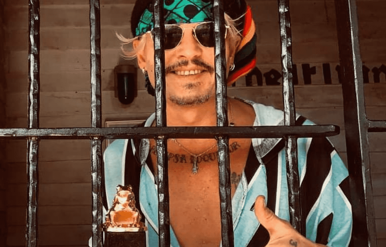 Imagem mostra Johnny Depp comemorando prêmio atrás das grades