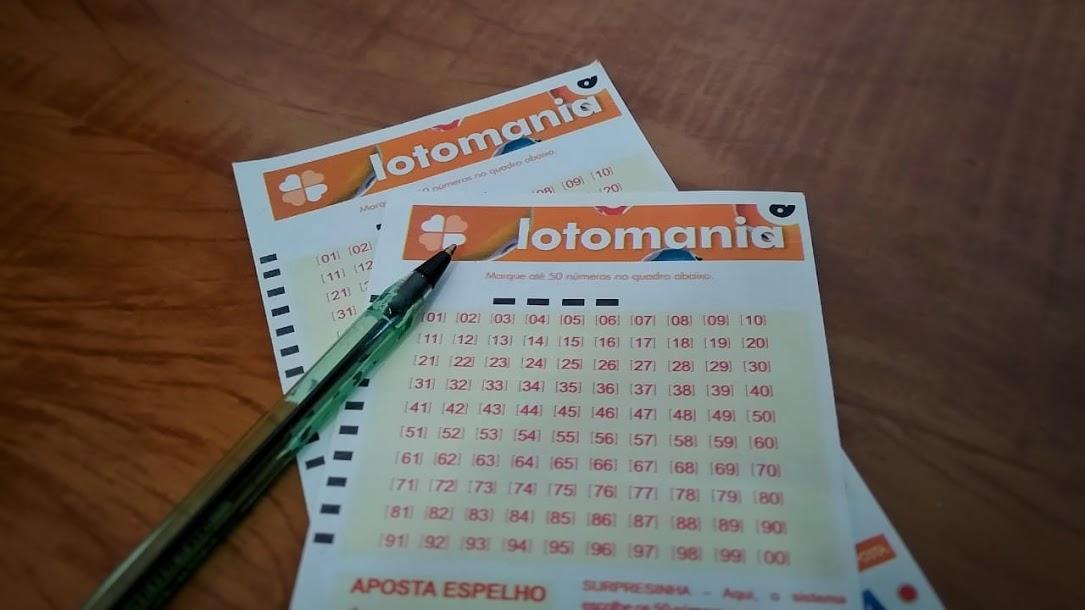 A imagem mostra dois volantes da Lotomania e uma caneta