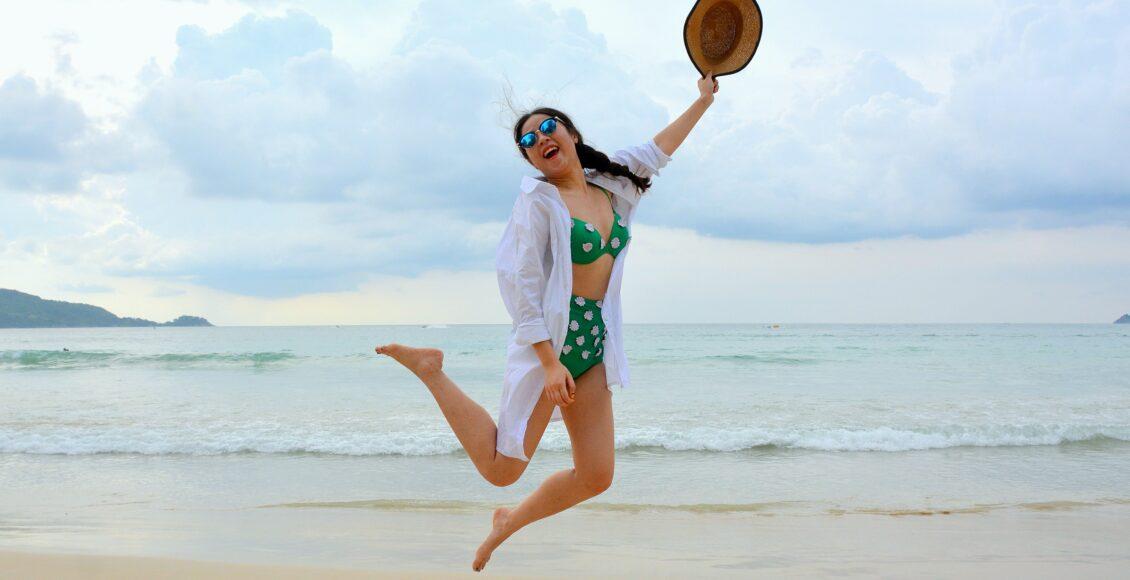 Mulher se diverte em praia com biquíni de cintura alta verde