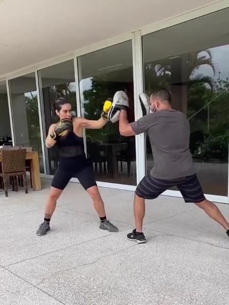 Imagem mostra cleo treinando com lutador