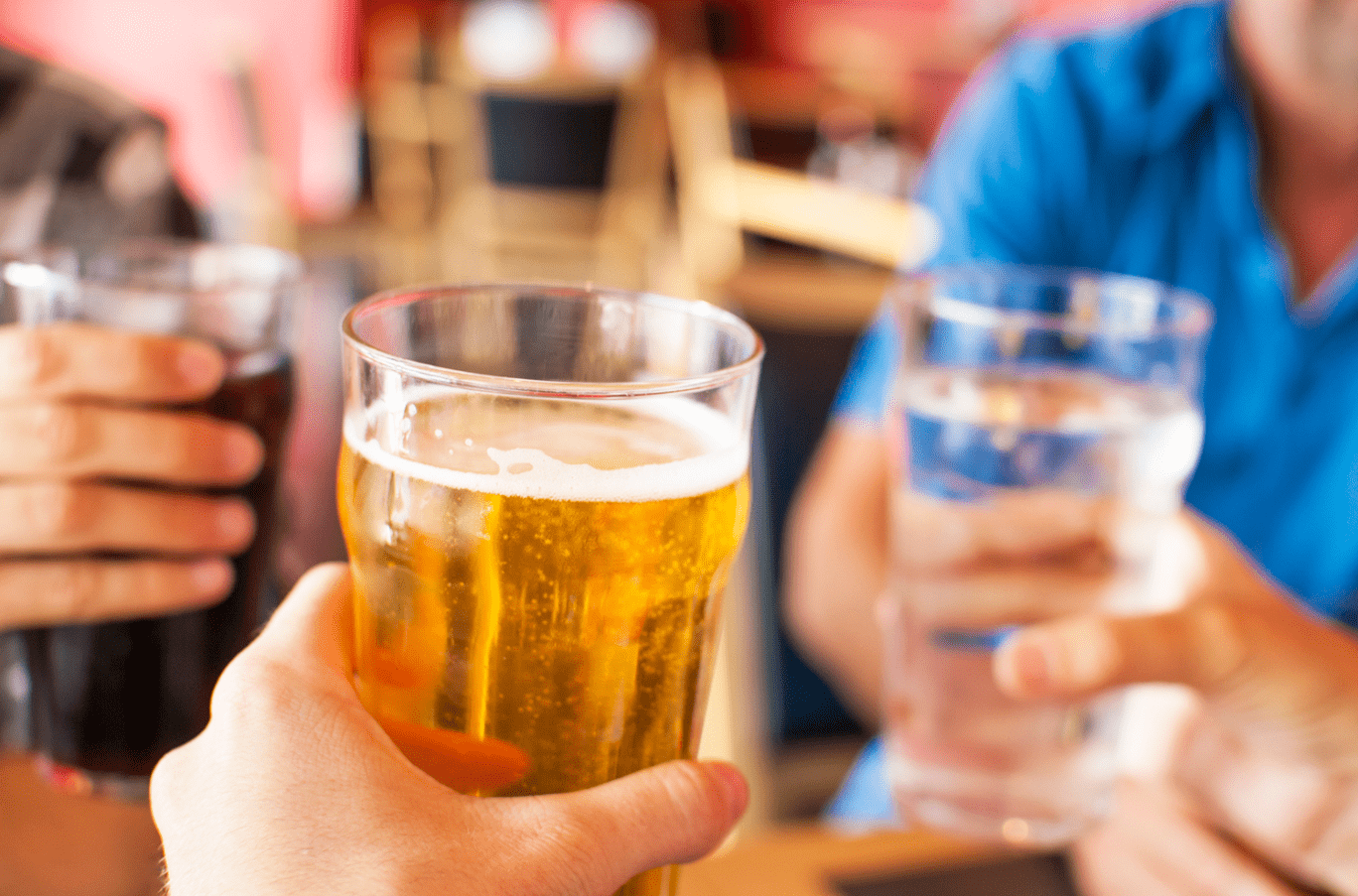 Foto mostra pessoas brindando com cerveja