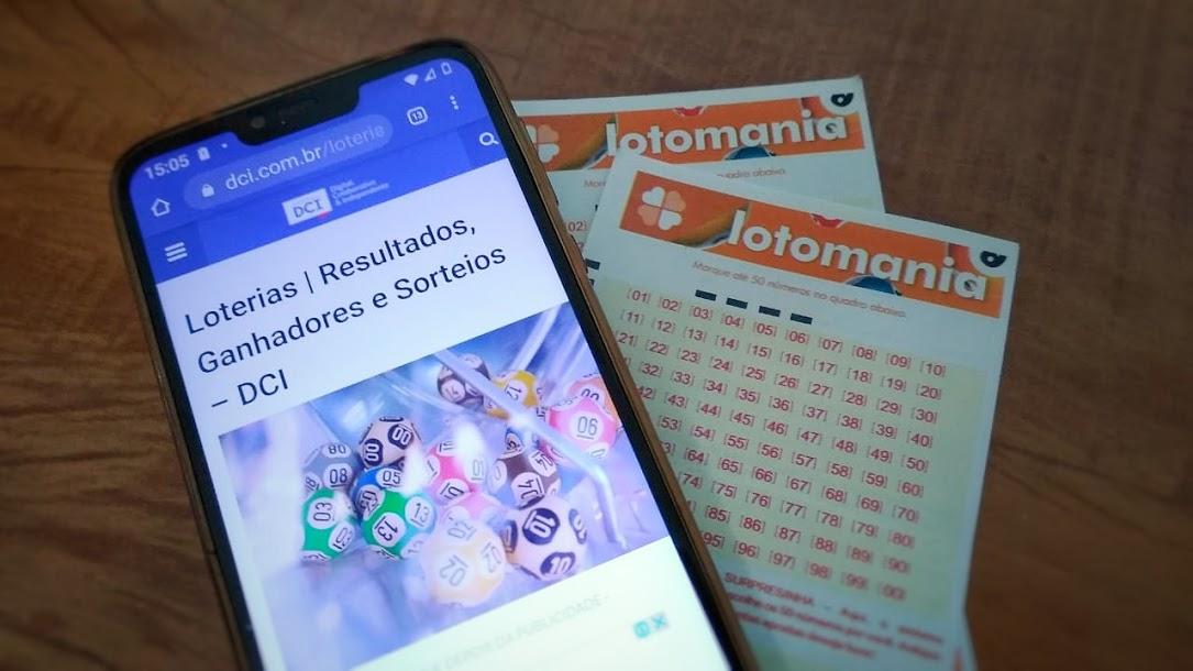 A imagem mostra um celular e dois volantes da Lotomania
