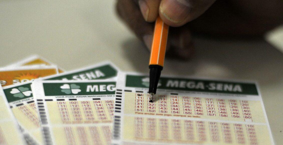 Mega Sena de ontem - A imagem mostra uma mão segurando uma caneta e marcando números no volante da Mega-Sena