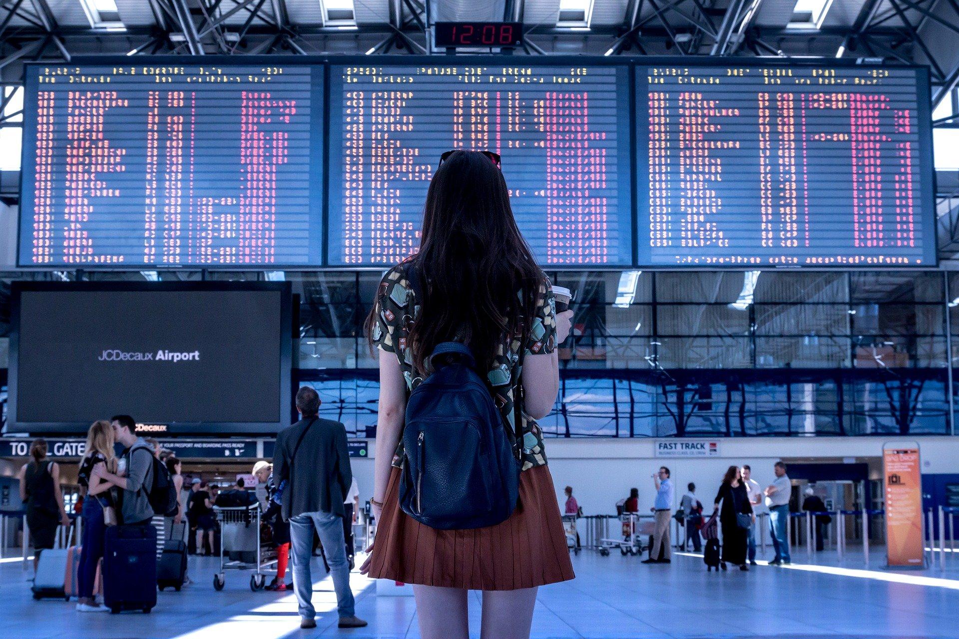 mulher encara painel de aeroporto rumo a países liberados para brasileiros