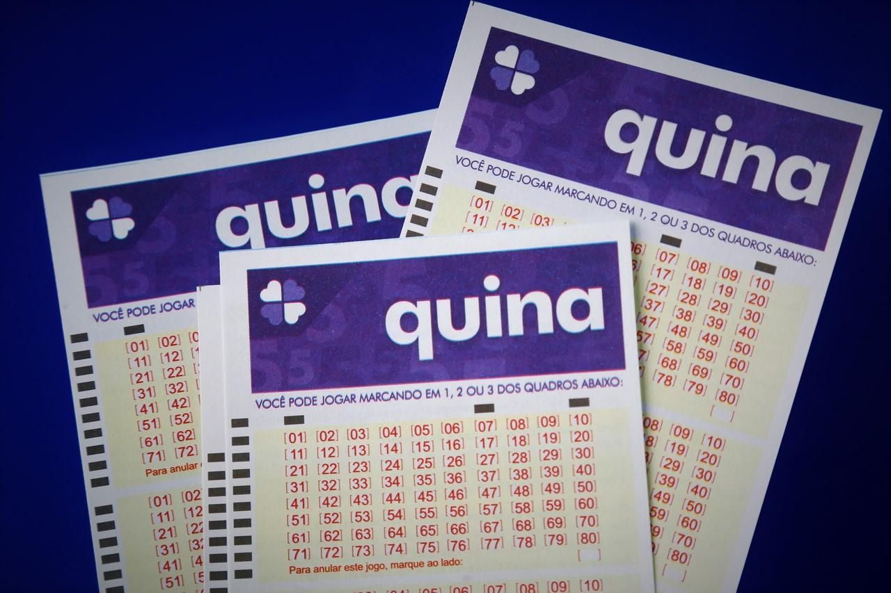 Bilhetes novos do resultado Quina sob um fundo plano em cor azul