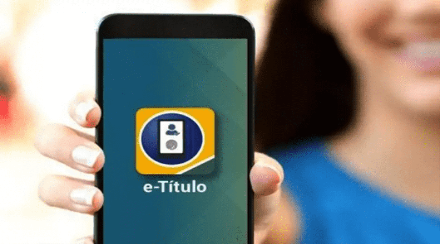 Foto mostra mulher segurança celular com tela no aplicativo e-título