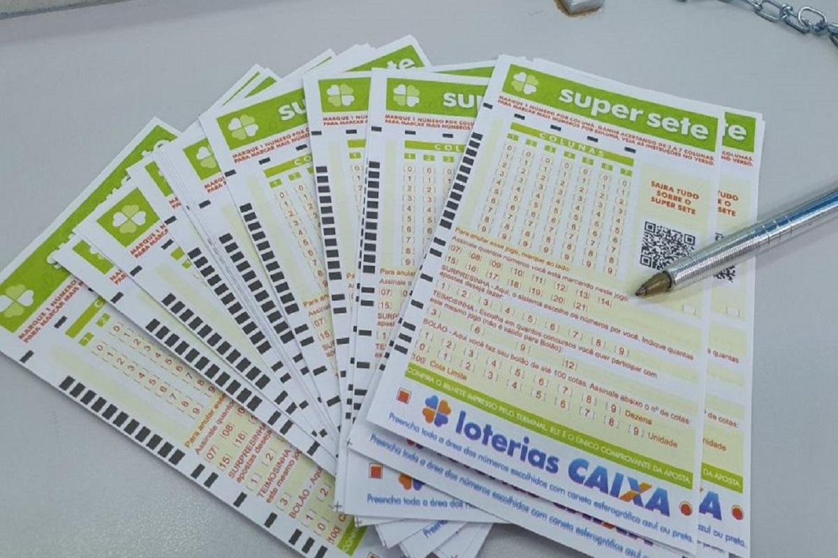 A imagem mostra diversos volantes do Super Sete organizados em leque em cima de uma mesa
