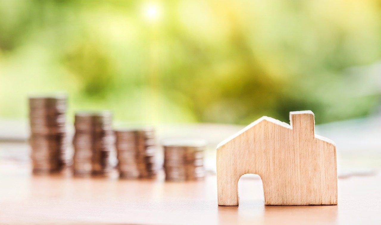 Miniatura de casa e moedas. Fundos imobiliários