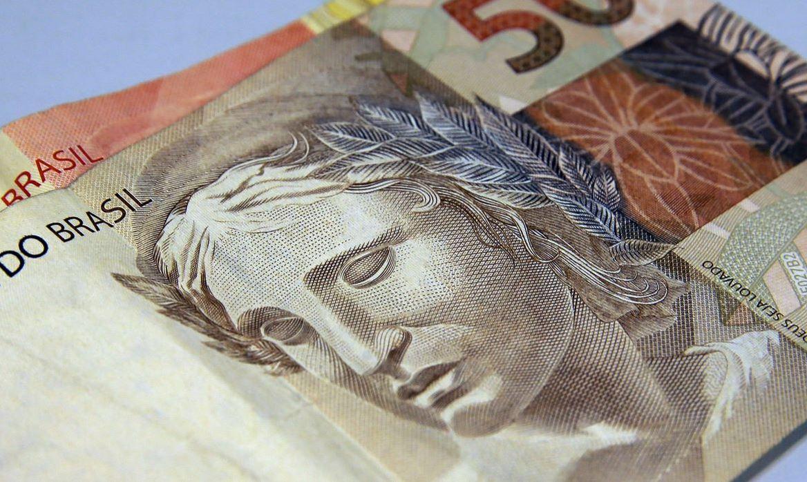 Foto aproximada mostra nota de 50 reais.
