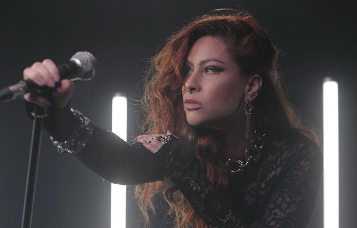 Imagem mostra cantora Pitty com microfone na mão
