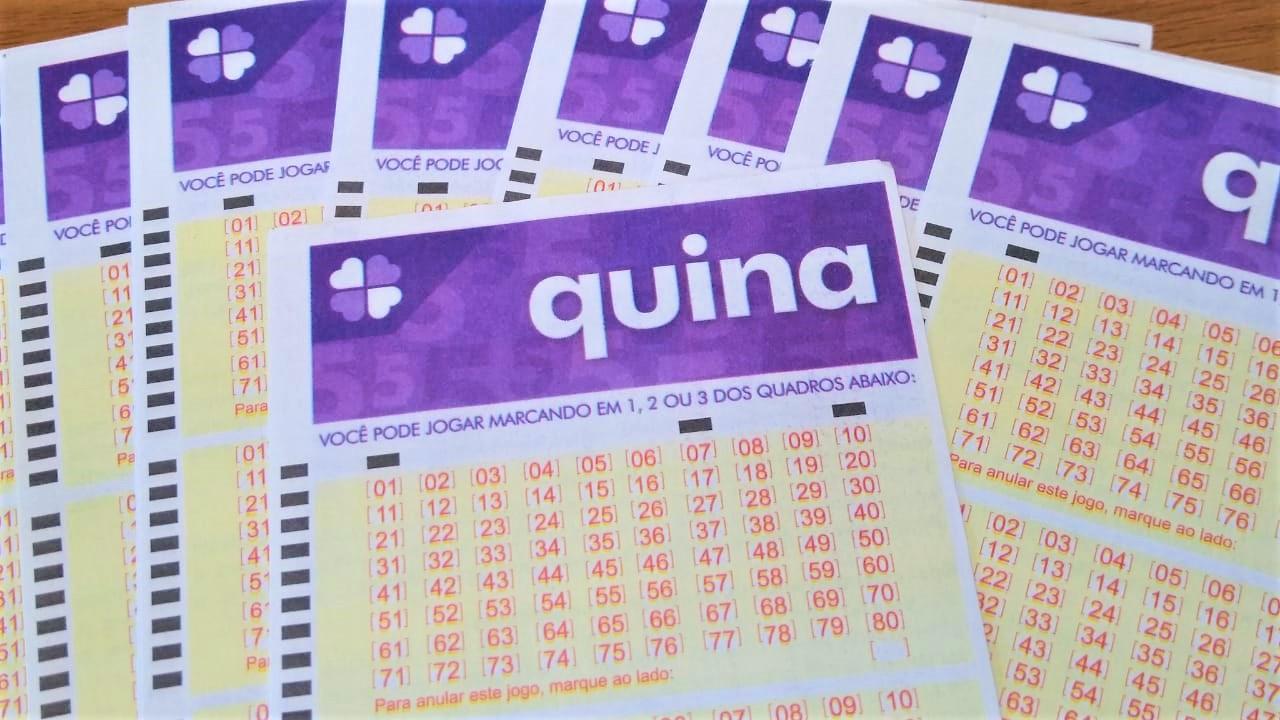 resultado da quina - bilhetes da quina em branco espalhados sob uma mesa em formato de leque com um bilhete em destaque por cima dos demais