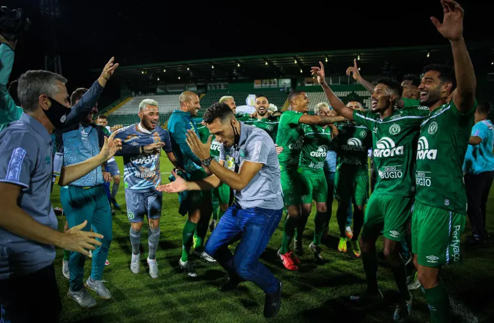 Ao centro da roda, Neto, outro sobrevivente do acidente, comemora o título