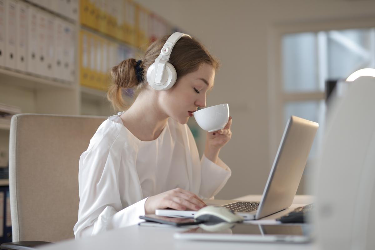 Mulher ouvindo música e tomando café