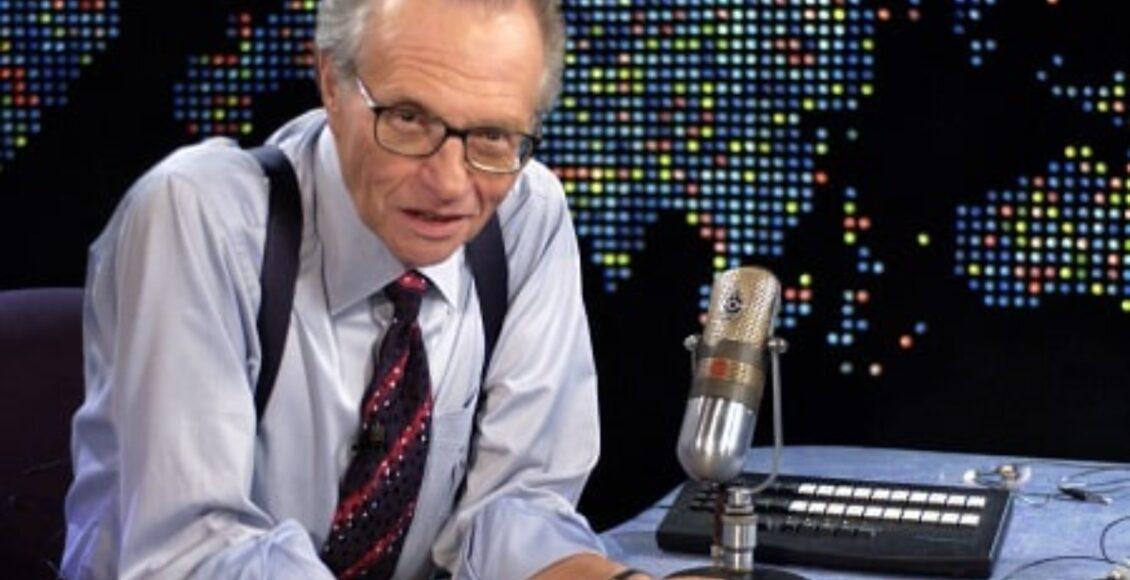 Imagem posada do jornalista Larry King sentado em uma bancada