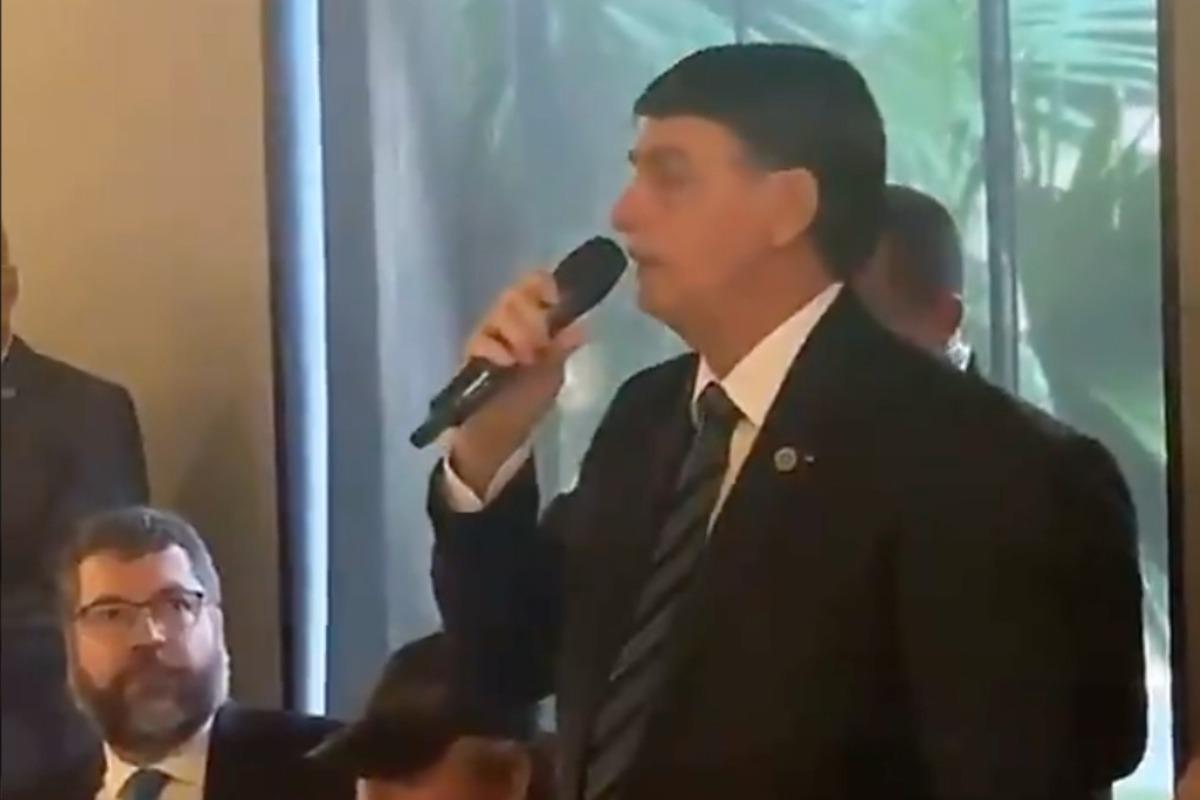 Imagem mostra Bolsonaro segurando um microfone durante uma reunião com seus apoiadores