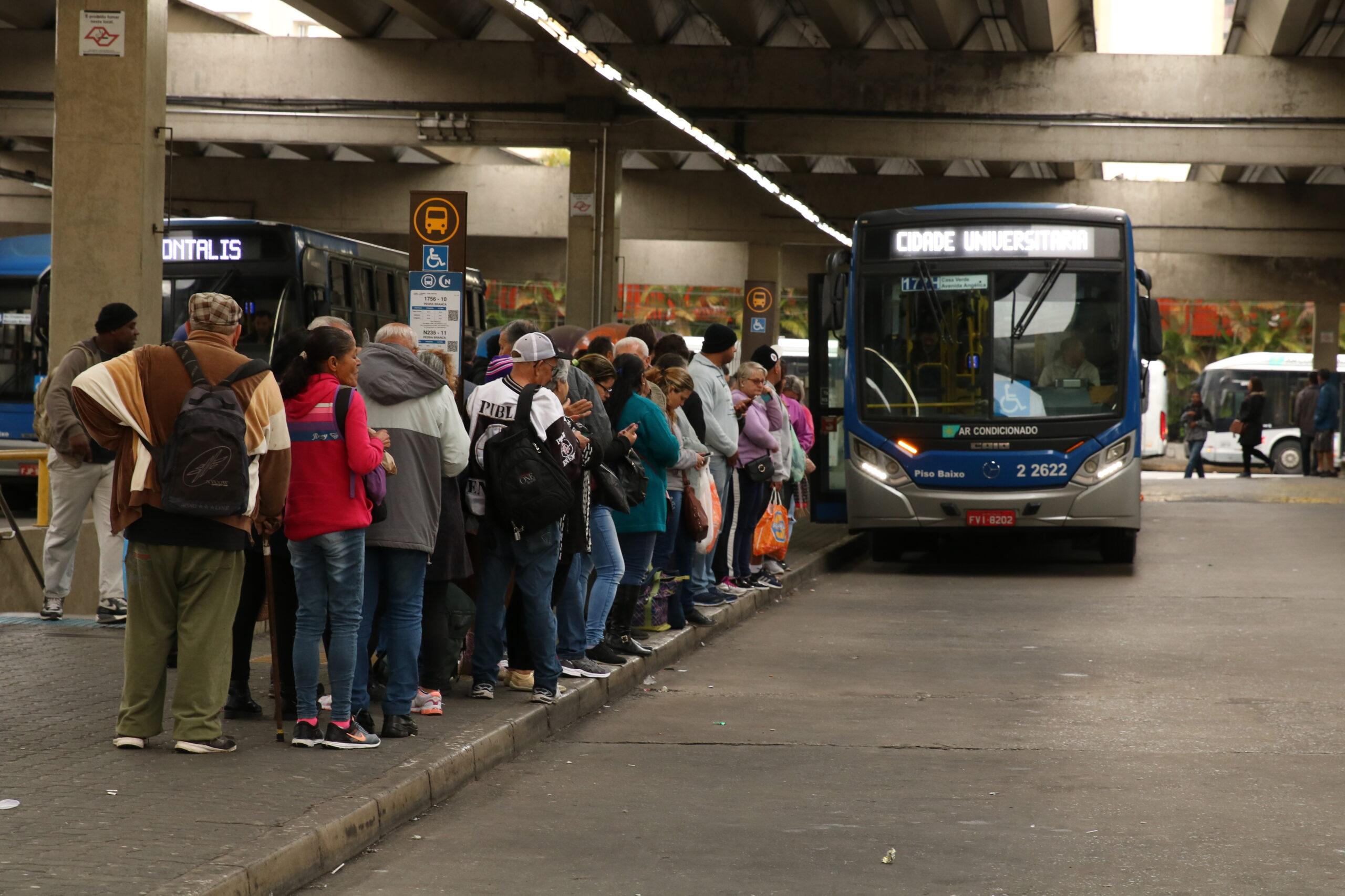 Fila de passageiros a espera de ônibus.