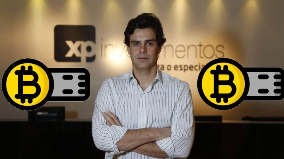 Guilherme Benchimol, presidente da XP, ao lado do logotipo do Bitcoin