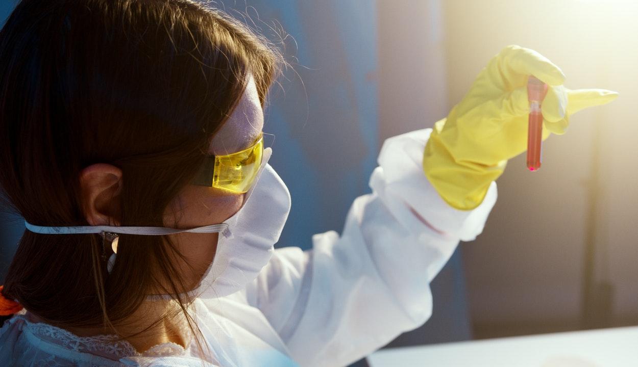 Imagem mostra cientista com luvas e óculos de proteção amarelos.