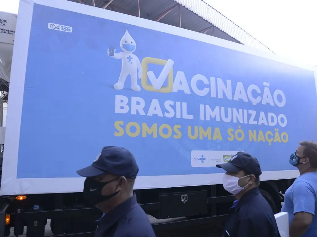 Imagem mostra agentes públicos com lotes das vacinas contra Covid-19