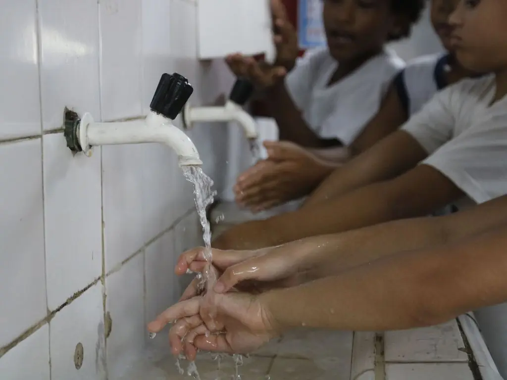 Imagem mostra crianças lavando as mãos nas torneiras na escola. A rede municipal escolar contará com ajude de mães, segundo prefeitura de sp covid