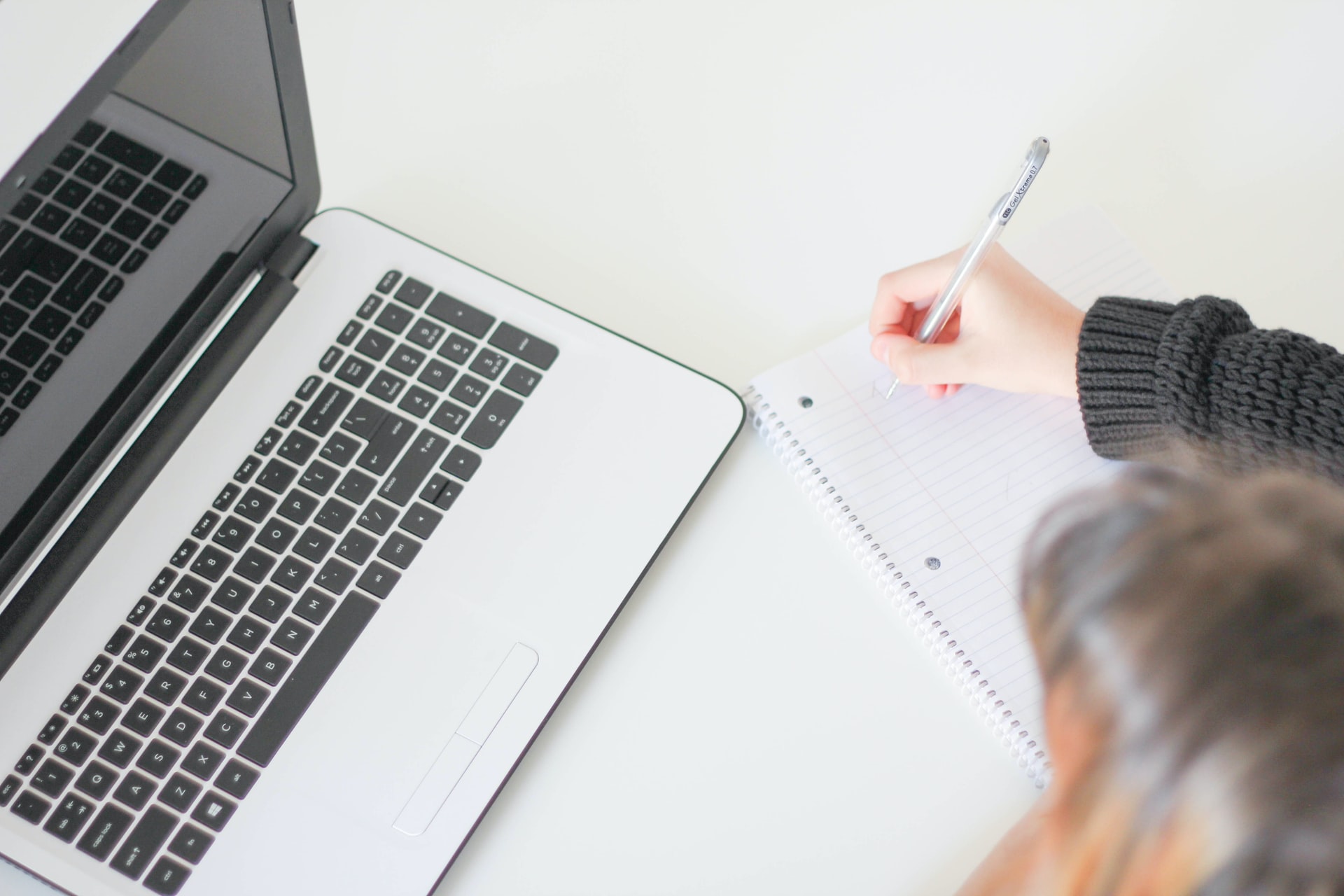 Mulher fazendo anotações em frente a notebook