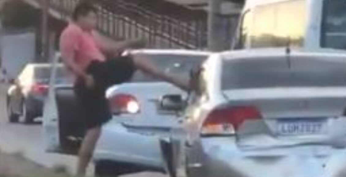Imagem mostra um homem chutando um carro na Avenida Brasil