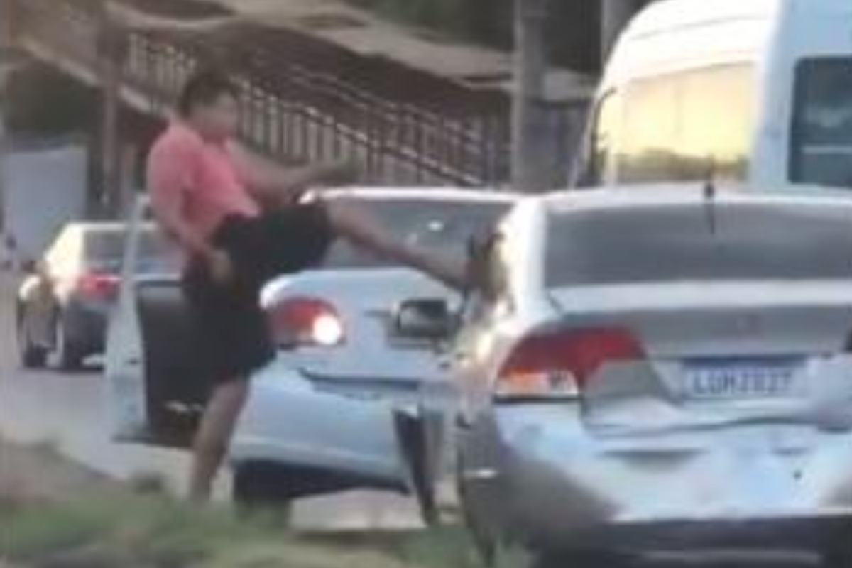 Imagem mostra um homem chutando um carro na Avenida Brasil