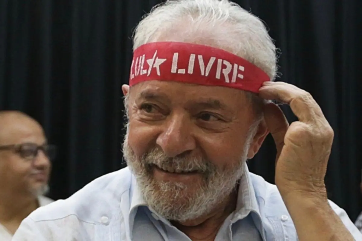 Imagem mostra ex-presidente Lula com uma faixa vermelha em sua cabeça 