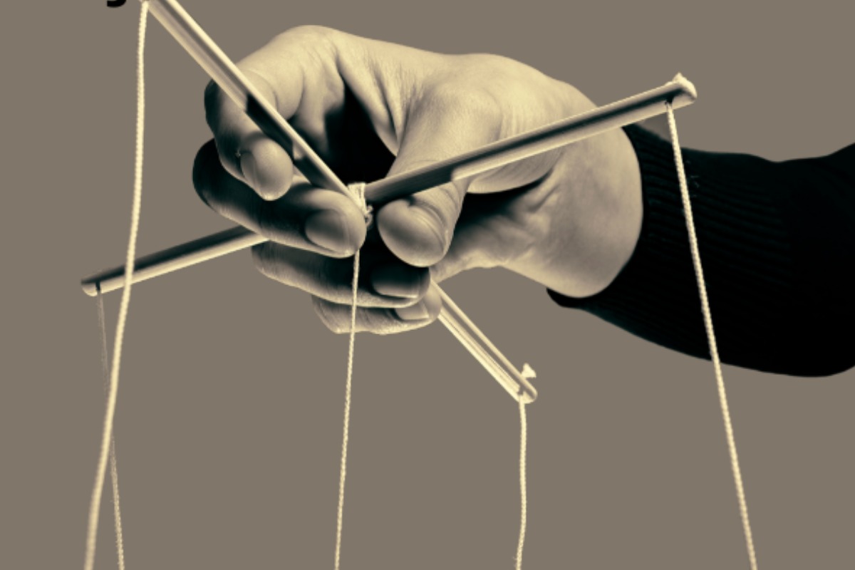 Imagem mostra uma mão segurando palitos e fios, fazendo alusão à manipulação e tortura psicológica