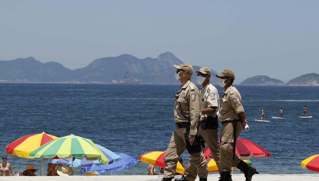 Imagem mostra policias caminhando na orla de copa cabana no Rio de Janeiro