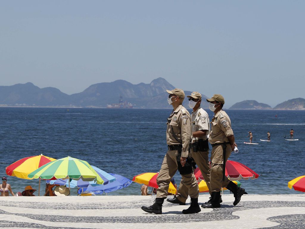 Imagem mostra policias caminhando na orla de copa cabana no Rio de Janeiro