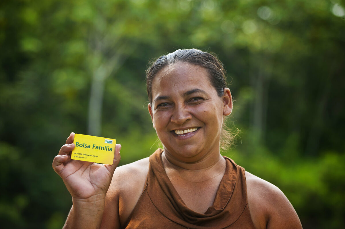 Mulher com cartão do Bolsa Família